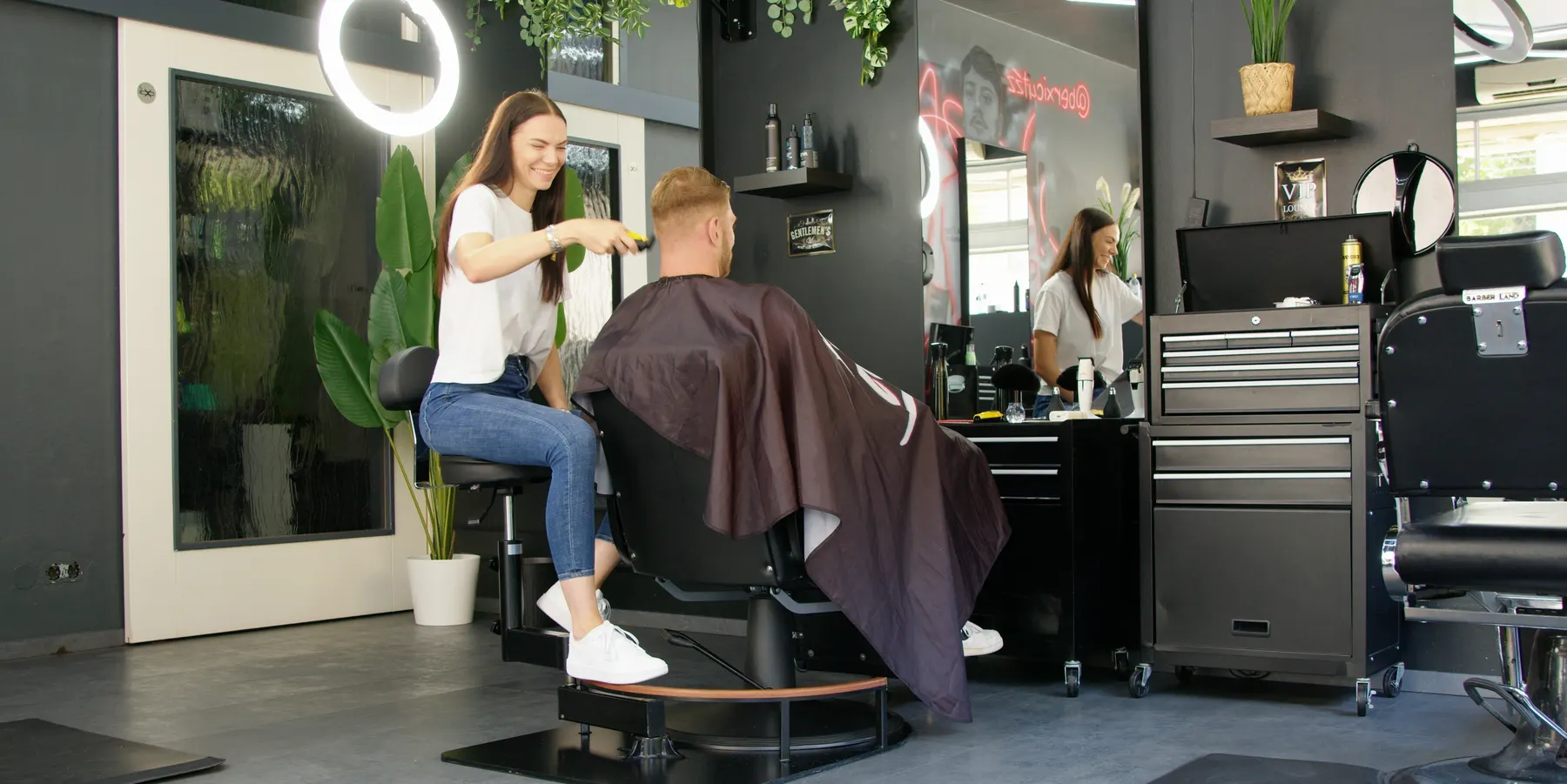 Barber seated on the OctoStool, cutting a client's hair